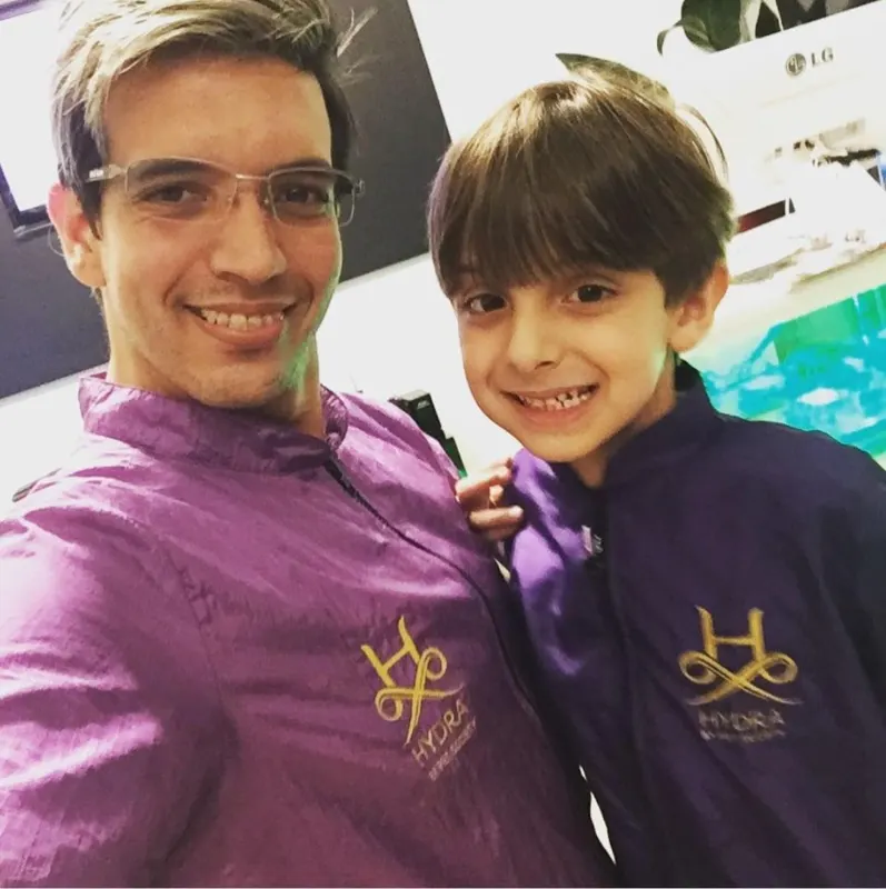 Paulo Roberto com o uniforme Hydra ao lado de um groomer